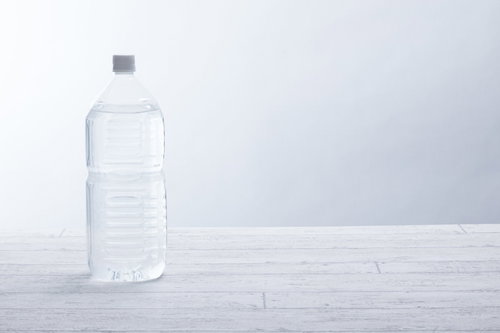 白い背景に置かれたミネラルウォーターの2リットルペットボトル
