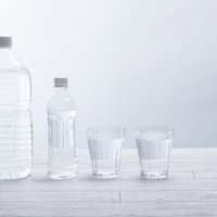 ペットボトルとグラスに入ったミネラルウォーターの写真