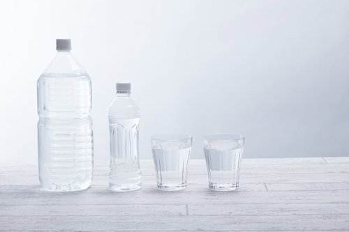 ペットボトルとグラスに入ったミネラルウォーター