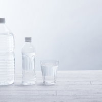 水分補給に欠かせないミネラルウォーター、ペットボトルとグラスの飲料の写真