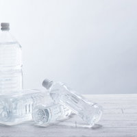 ペットボトルが次々と崩れる瞬間、複数本が連鎖して倒れる動的な構図の写真