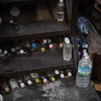 住宅街の階段に並ぶ猫よけペットボトルの対策状況の写真