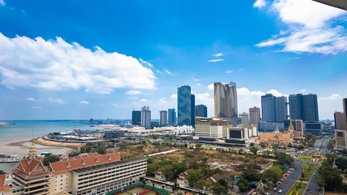 青空と白い雲を背景にした高層ビルが立ち並ぶプノンペンの都市風景