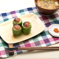 ピーマンに詰め込んだ焼きおにぎりの食卓風景の写真