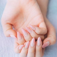 ピンク色のネイルアートをした両手のネイルカラーの写真