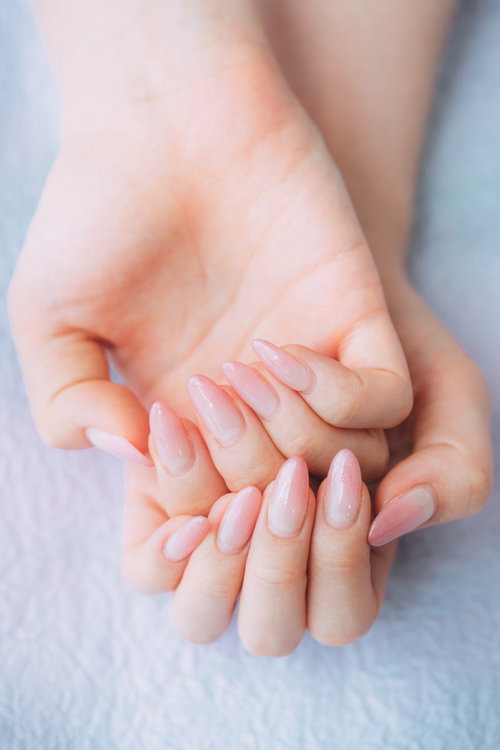 ピンク色のネイルアートをした両手のネイルカラー