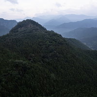 鬱蒼と生い茂る山々が重なり合う霞がかかった遠景の写真