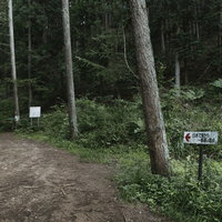 日本で海から一番遠い地点の山道脇に設置された案内板の写真