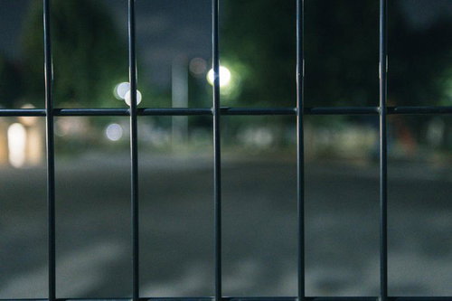 フェンスがあって先に進めない夜間の光景、進入禁止の暗い街灯照らす夜景