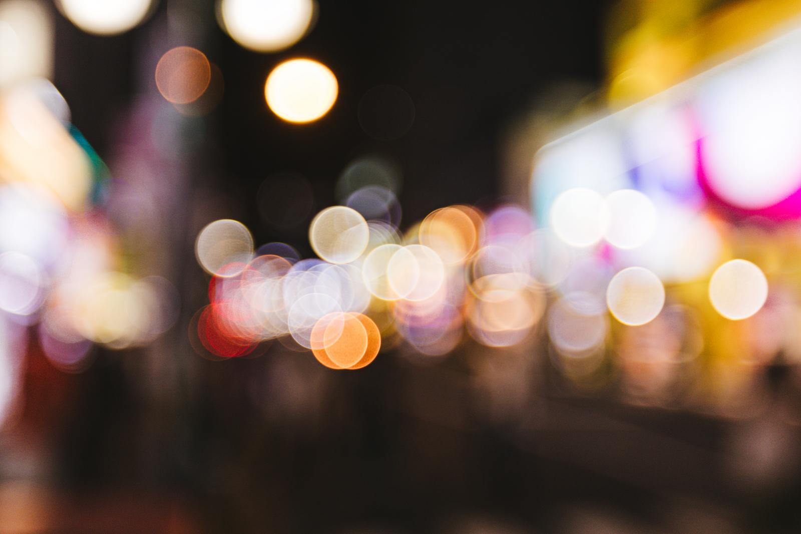 繁華街のネオンライトがボケて玉ボケになった夜景写真