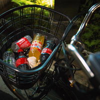 駐輪している自転車のかごに投げ込まれたペットボトルのポイ捨て問題の写真