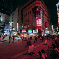 人で溢れるシネシティ広場の夜景、歌舞伎町タワーとゴジラ看板が輝く新宿の写真