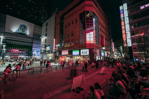 人で溢れるシネシティ広場の夜景、歌舞伎町タワーとゴジラ看板が輝く新宿