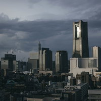 日没間際の横浜みなとみらいのランドマークタワーと高層ビル群の写真