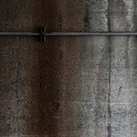 グレーのコンクリート壁に設置された細い配管のテクスチャーの写真
