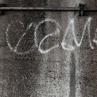 白い落書きが描かれたコンクリート壁のテクスチャーの写真