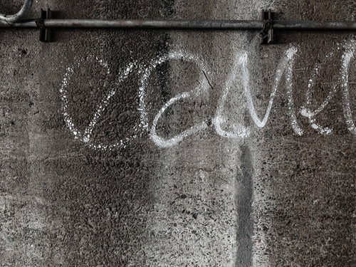 白い落書きが描かれたコンクリート壁のテクスチャー