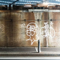 白いスプレーで描かれた落書きのあるコンクリート壁の写真
