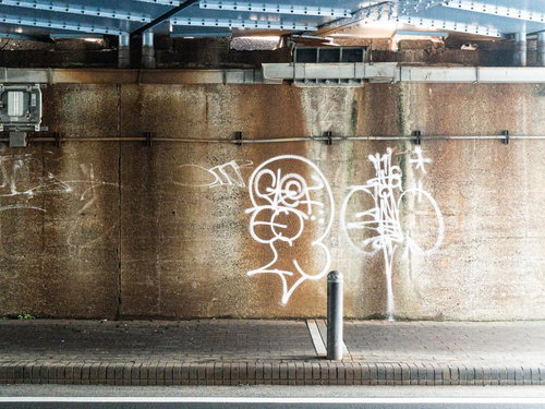 白いスプレーで描かれた落書きのあるコンクリート壁