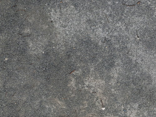 コンクリートの地面に散らばる砂とざらついた表面