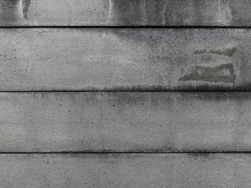 何層ものコンクリート壁に横走する継ぎ目と表面の質感