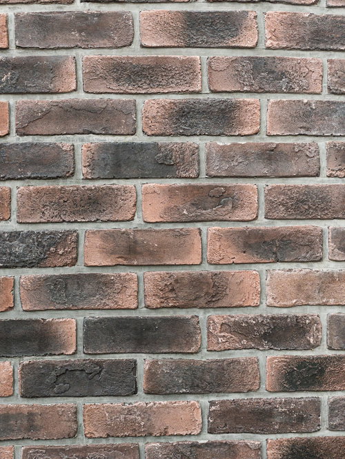 埋め込まれた黒染み煉瓦の壁のテクスチャー