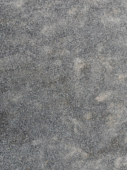 細かい砂粒が広がるグレーの砂地の地面