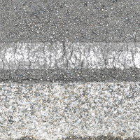 アスファルト路面に薄く残る劣化した白線のテクスチャーの写真
