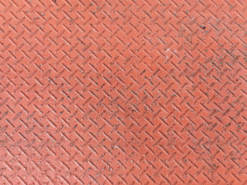 赤く塗装された縞鋼板のテクスチャー