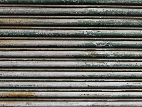 剥げた塗装と錆が浮く金属製シャッターのテクスチャー