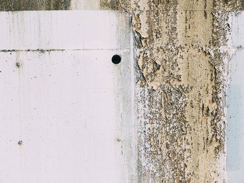 劣化による塗装が禿げたブロック塀