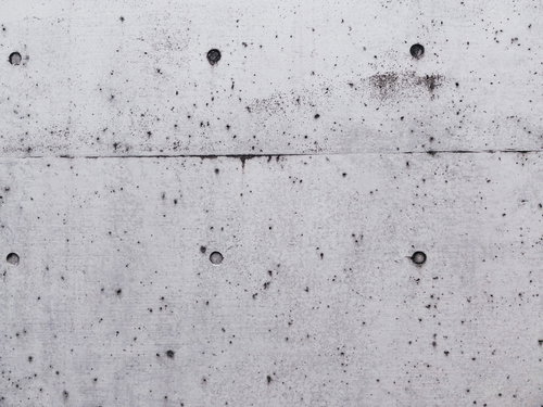 黒く汚れたセパ穴のコンクリート打ちっぱなし壁テクスチャー