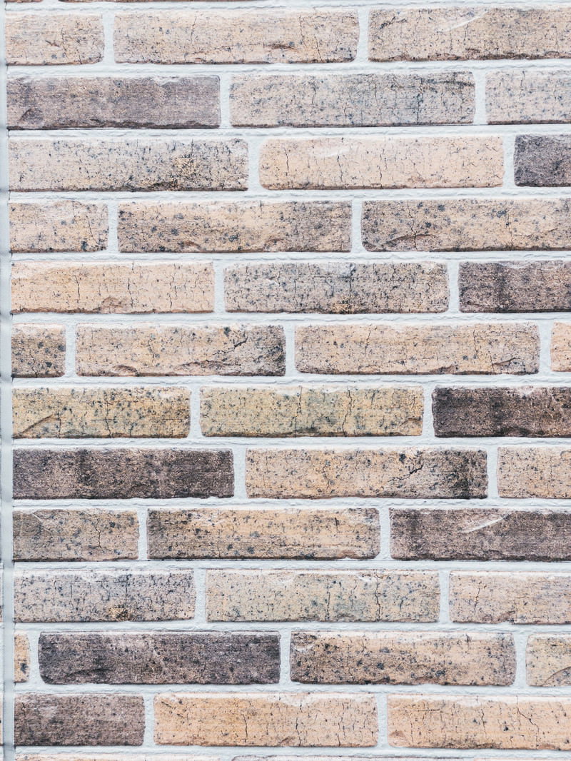 ベージュとグレー系の薄色レンガが積まれた壁のテクスチャー