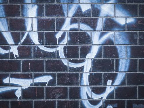 青と白のスプレーで描かれた落書きされた壁