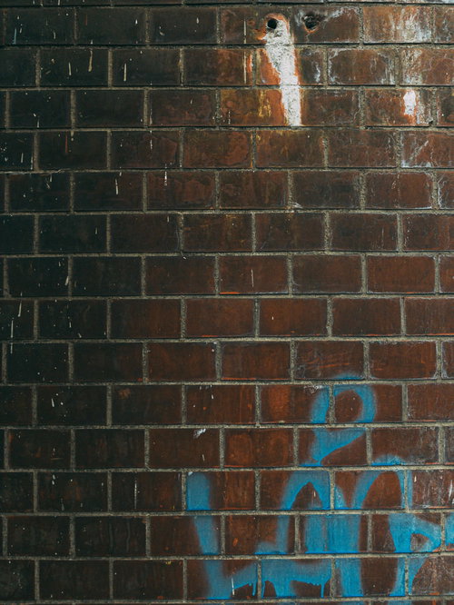 赤茶色のレンガ壁に青いスプレーで描かれた落書き（テクスチャ）