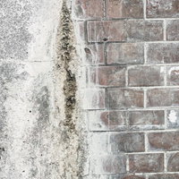 経年劣化で汚れがこびりついたコンクリートとレンガの外壁（テクスチャ）の写真