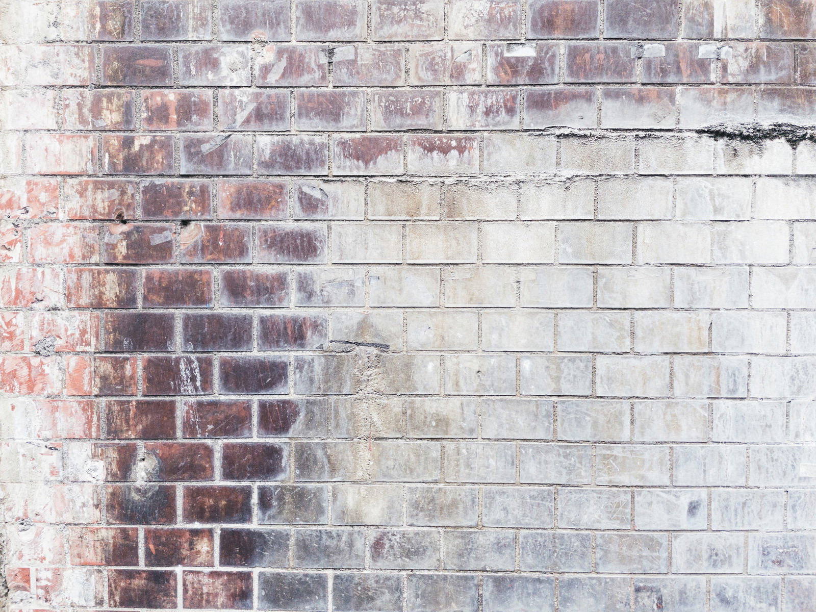 白華現象により白い汚れが付着した赤茶色のレンガ壁のテクスチャ