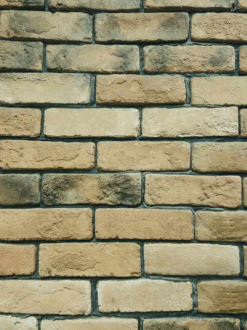 経年劣化で色あせた古いレンガ壁のテクスチャー