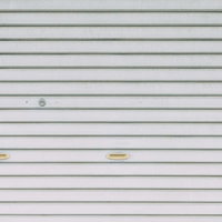 白い金属製シャッターと鍵穴のテクスチャの写真