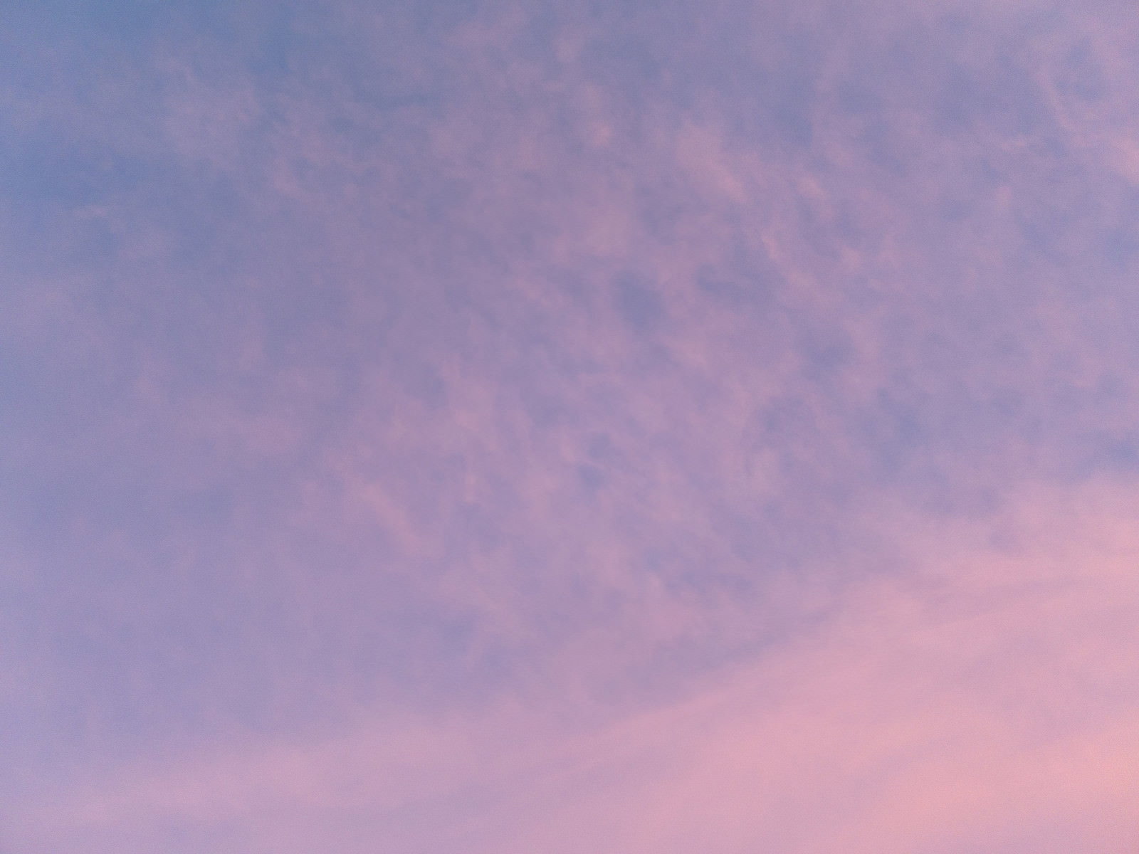夕焼けの空に薄い雲が浮かぶ、ピンクから紫のグラデーション