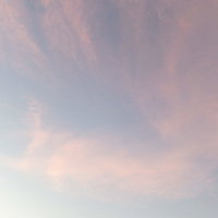 焼けたオレンジ色の空と流れる薄雲の夕暮れ風景の写真