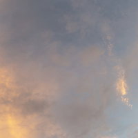 黄昏時の薄雲が広がる夕焼け空、オレンジとグレーの夕暮れ風景の写真