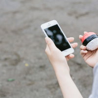 歩きながらのゲームは大変危険です 紅白ボールを持つ子どもとスマートフォンの写真