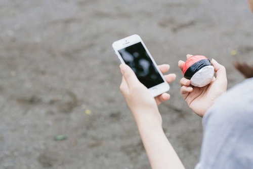 歩きながらのゲームは大変危険です 紅白ボールを持つ子どもとスマートフォン