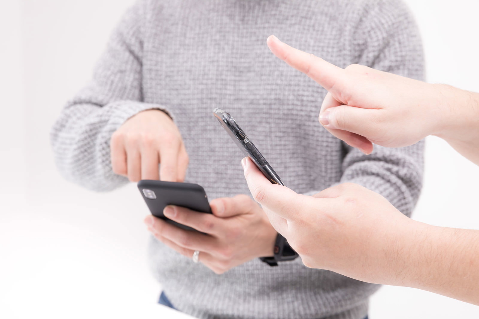 スマートフォンを持つ人に指差しで説明するふたり