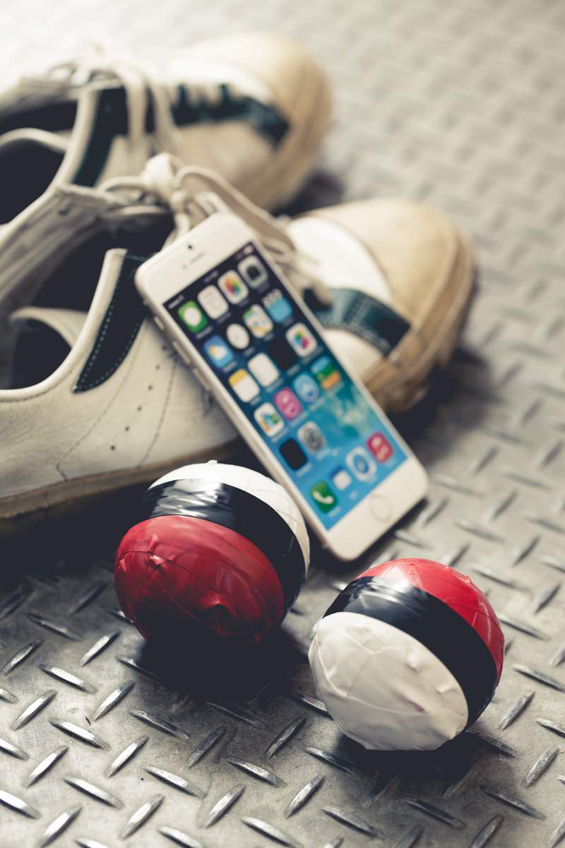 金属の床に並ぶスニーカーとスマホとヘッドホン