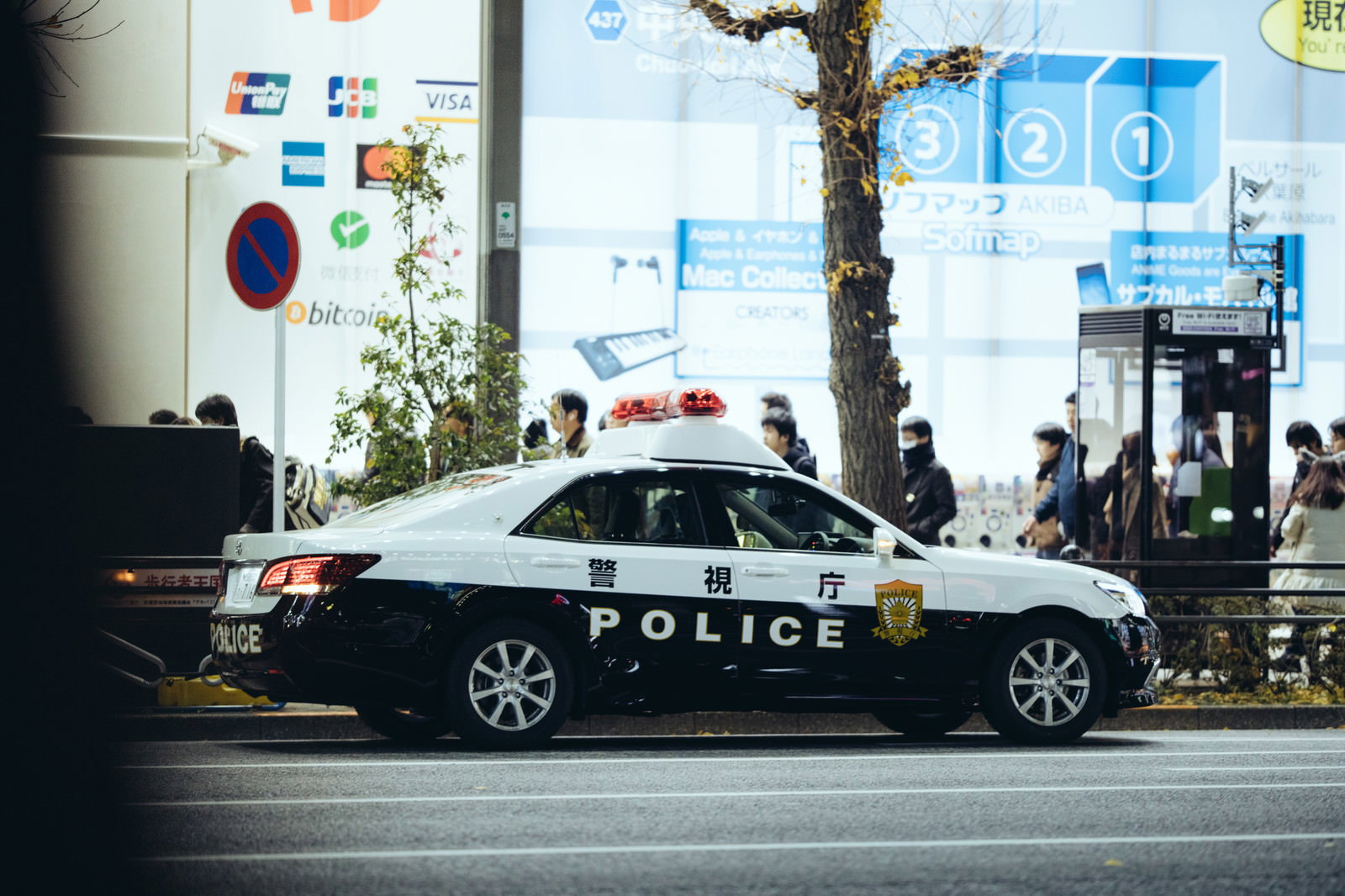 路肩に停車している白と黒のパトカーと街の風景