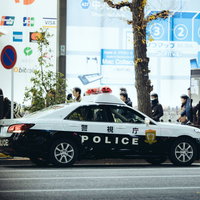 路肩に停車する白と黒のツートンカラーのパトカーの写真