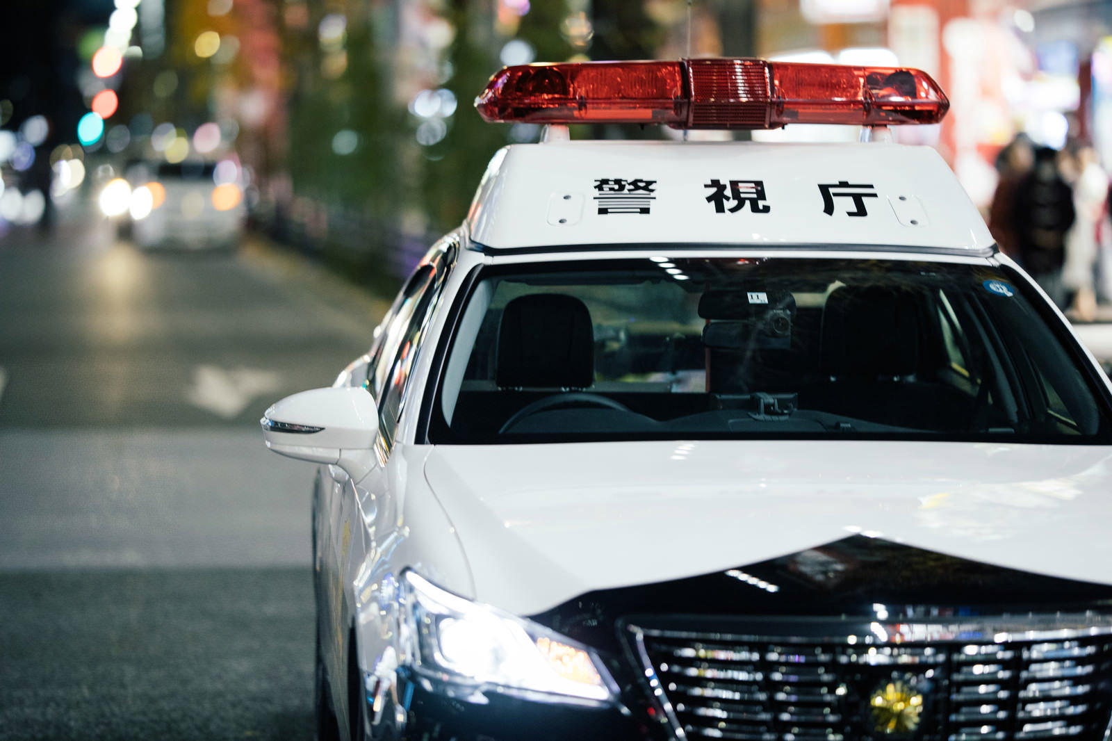 夜の街に停車する赤色灯が点灯したパトカー