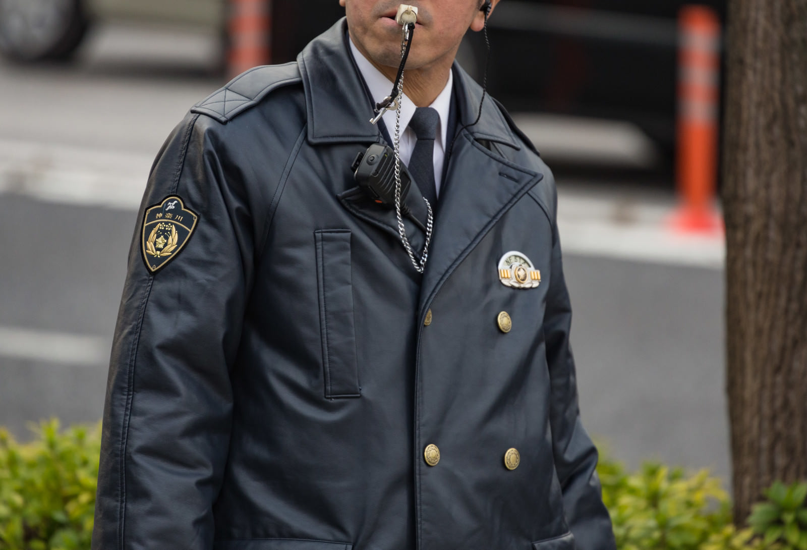 笛を吹いている紺色制服の警察官